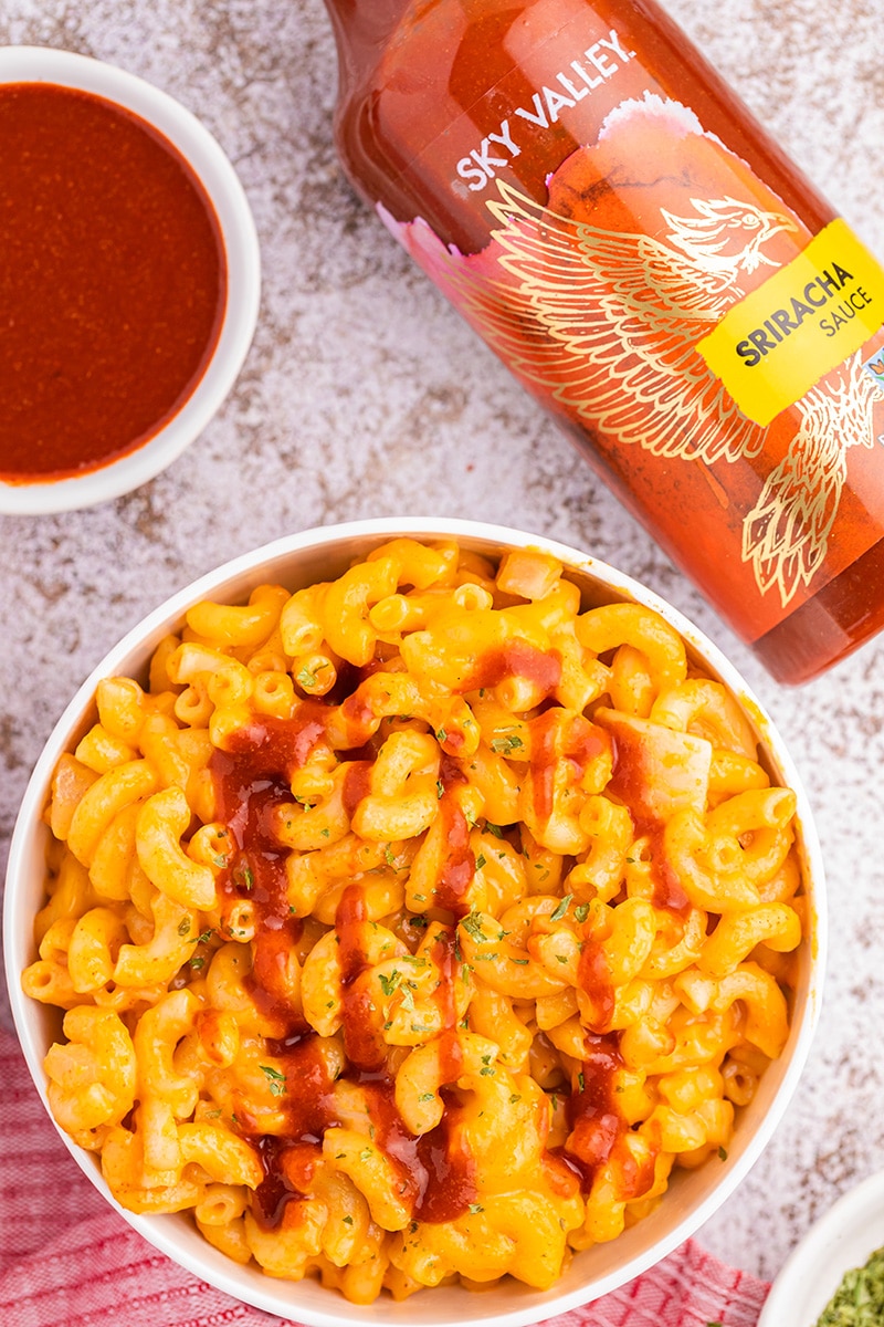 Drizzling Sky Valley Sriracha Sauce on Sriracha Mac and Cheese